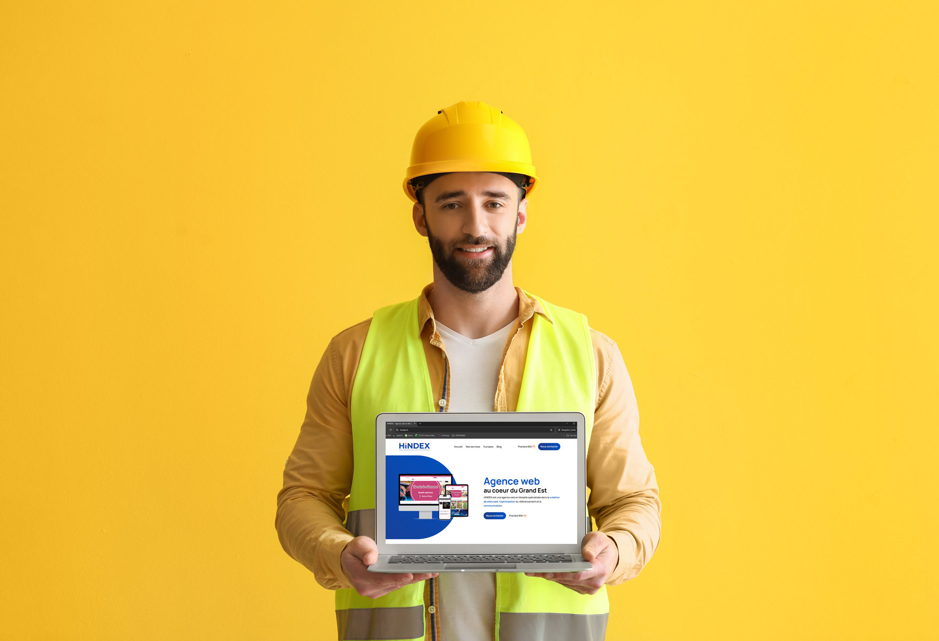 Un homme en tenue de chantier tenant un ordinateur dans la main. Créer un site web pour votre entreprise en Moselle.